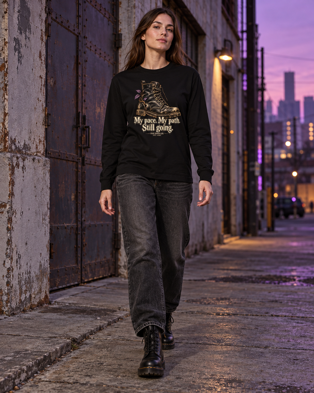 Unisex black long sleeve graphic tee, model wearing boot graphic and 'Still going' text