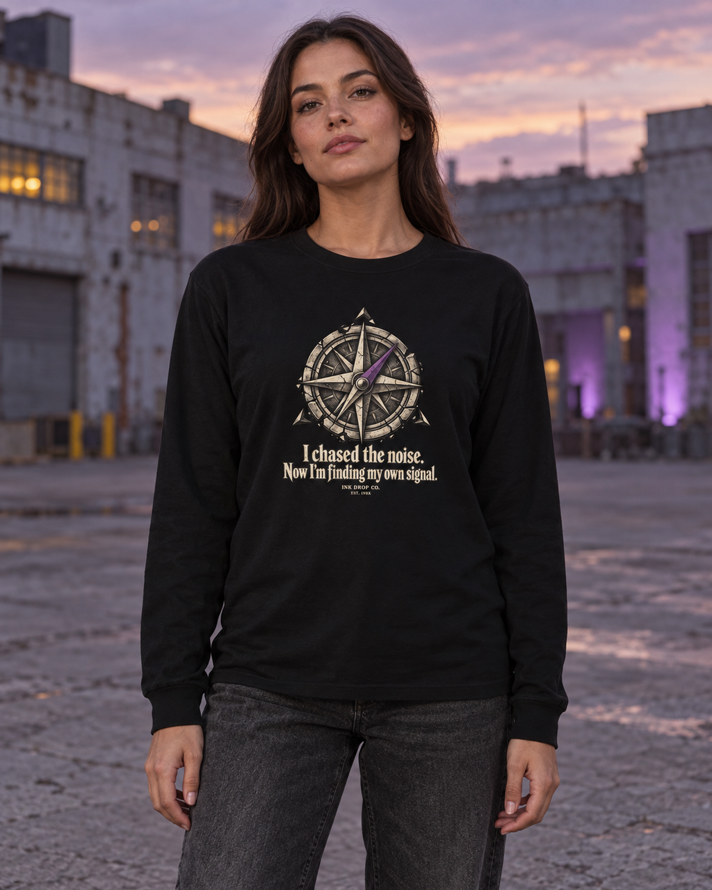Black unisex long sleeve crewneck tee on model with compass graphic and slogan on chest