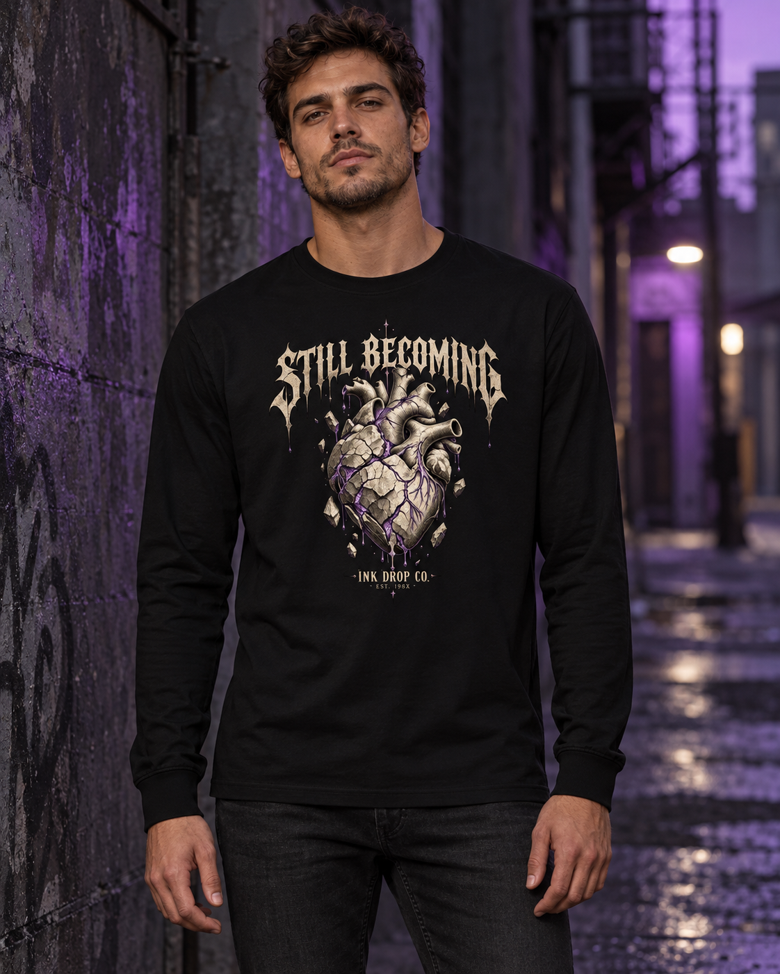Black unisex long-sleeve graphic tee on model, front heart and text print visible
