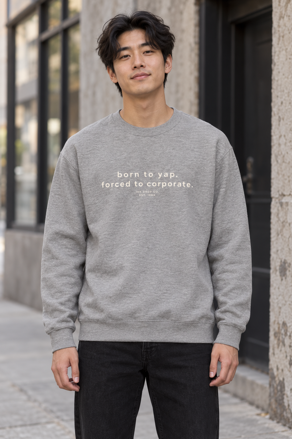 Unisex crewneck sweatshirt in light heather grey, worn front with small text graphic