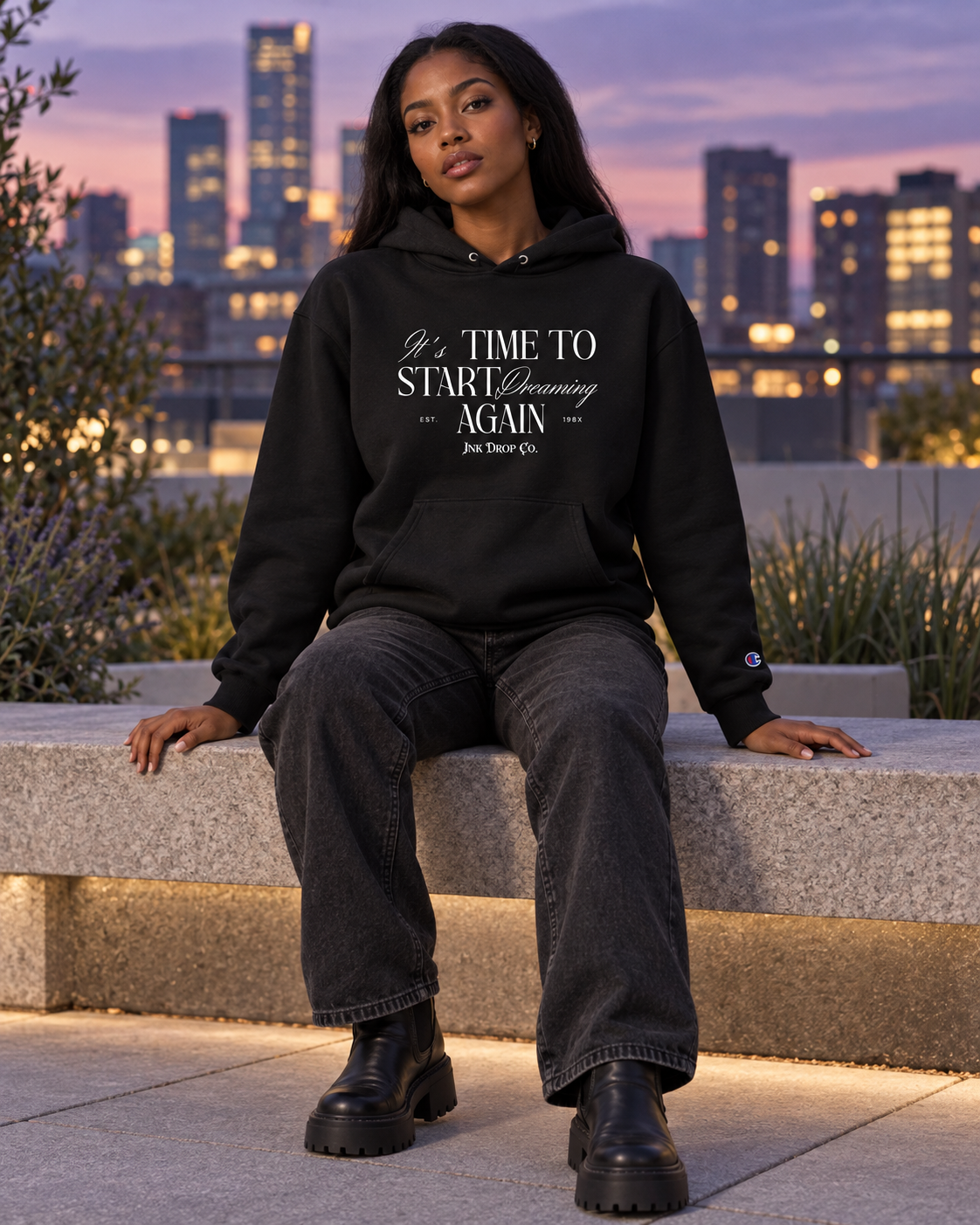 Unisex black graphic hoodie worn by a person outdoors, hood and chest print visible