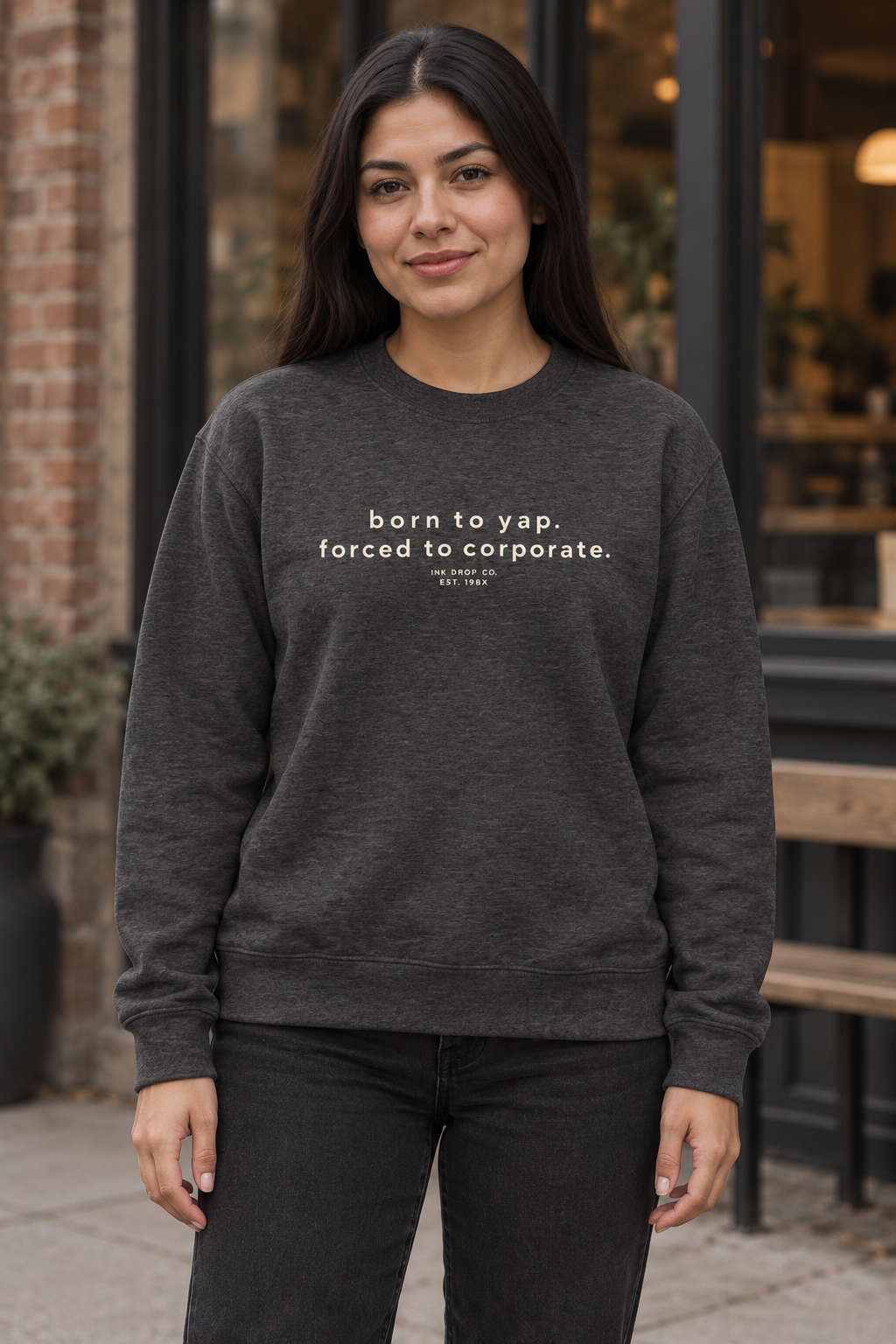 Unisex crewneck sweatshirt in dark heather grey, worn front with small text graphic