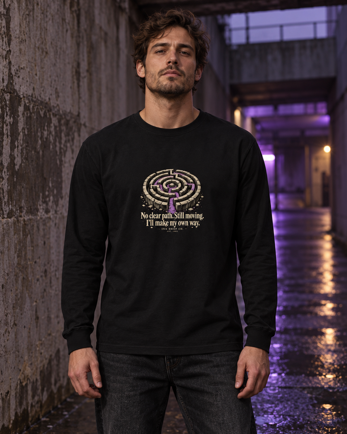 Unisex black long-sleeve graphic tee worn by model, maze emblem and slogan on chest