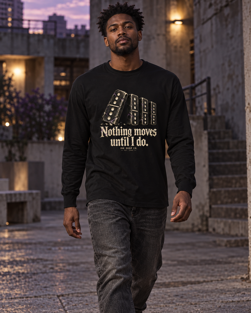 Black unisex long-sleeve tee with gold domino graphic, worn by model