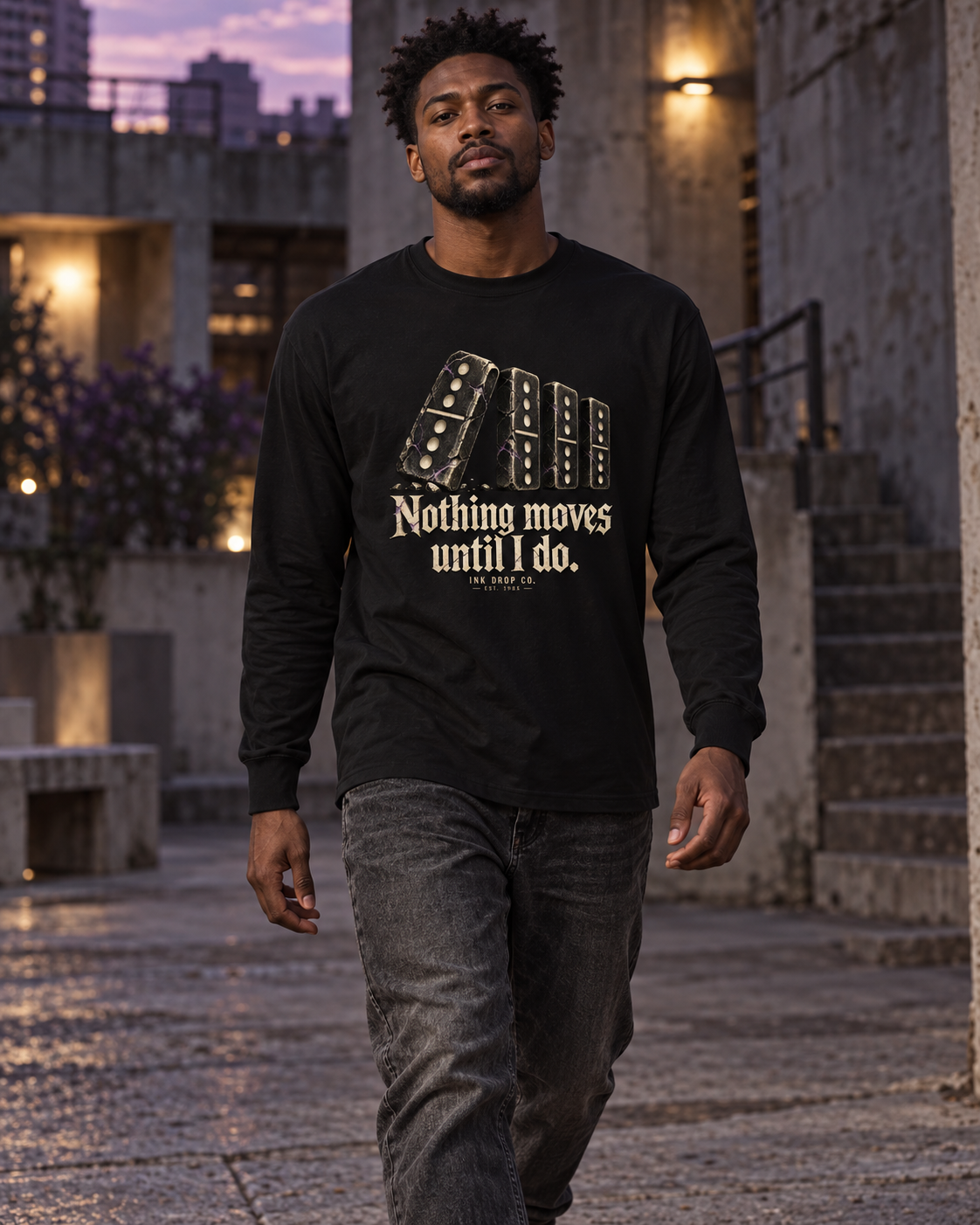 Black unisex long-sleeve tee with gold domino graphic, worn by model
