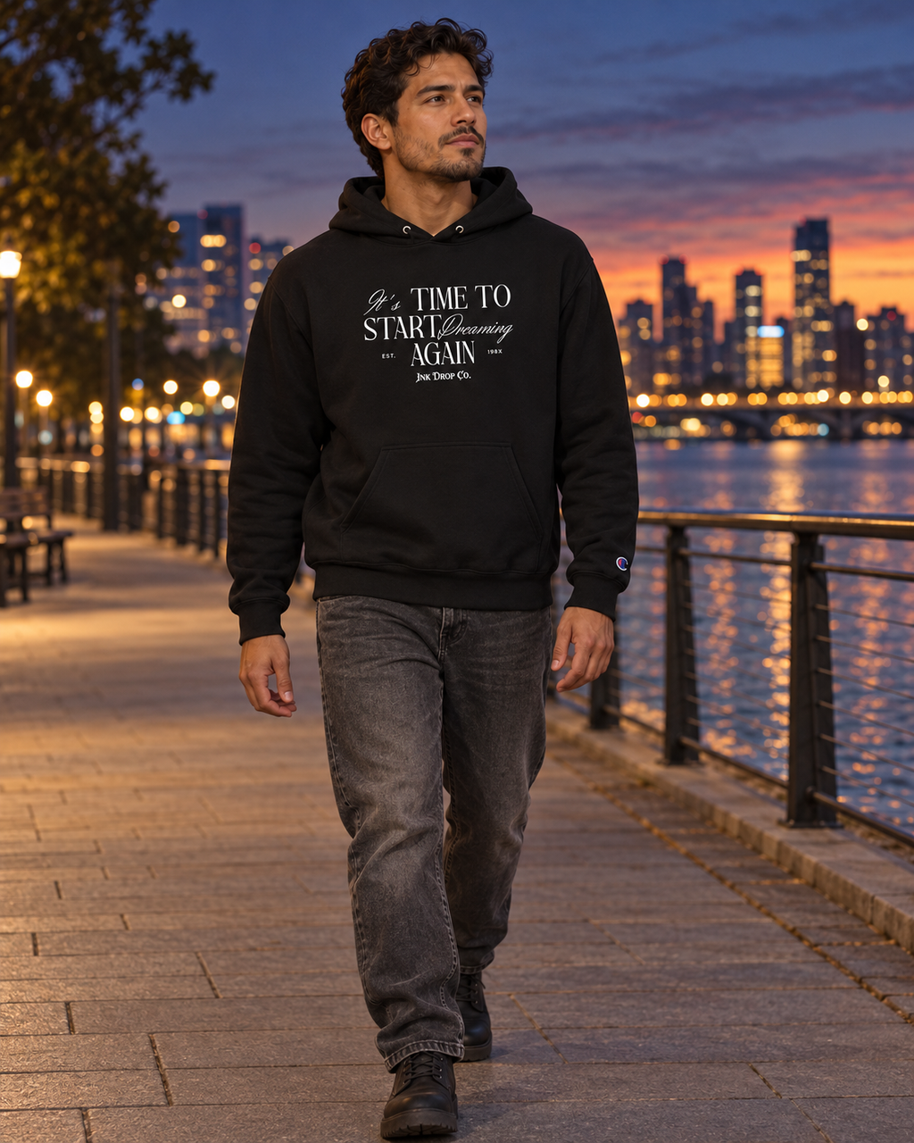 Unisex black graphic hoodie worn by a person outdoors, hood and chest print visible