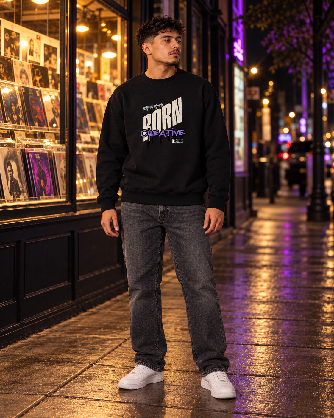 Black crewneck sweatshirt with Born Creative graphic, long sleeves on model