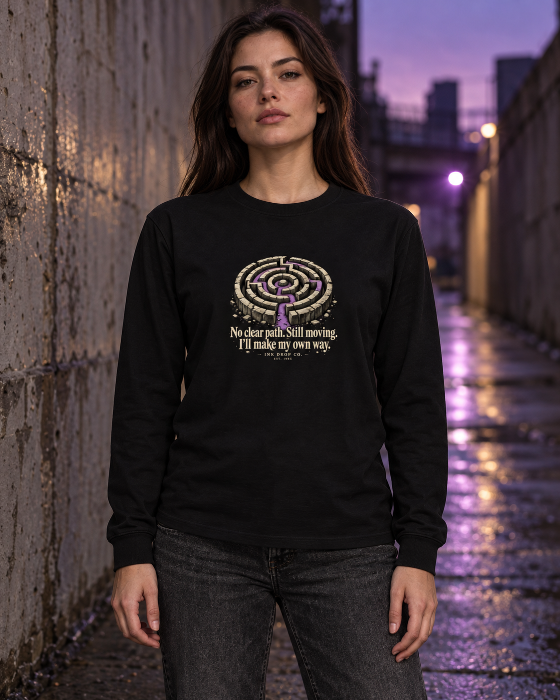 Unisex black long-sleeve graphic tee worn by model, maze emblem and quote on chest