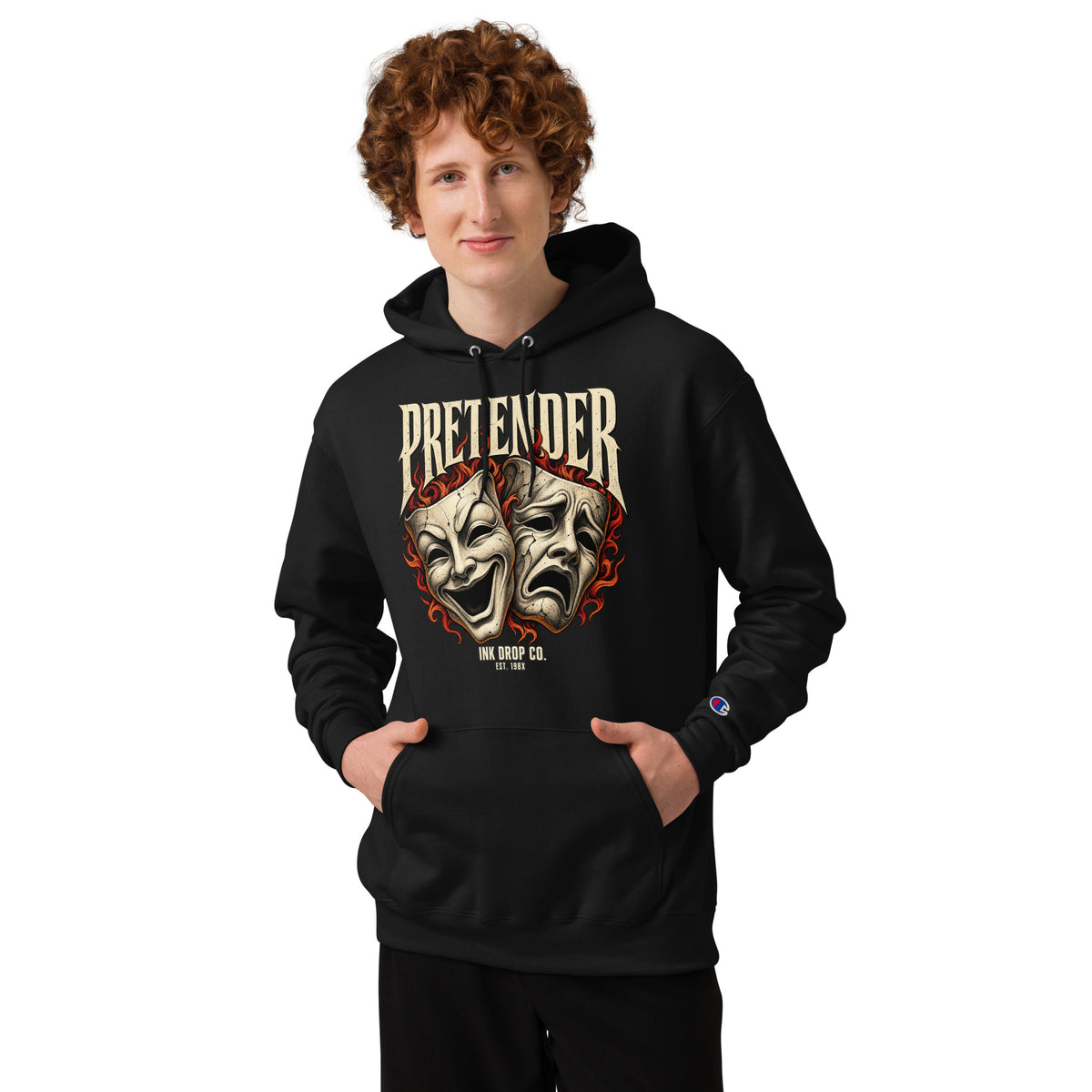 Black Champion hoodie with theater mask graphic, modeled with hands in the front pocket