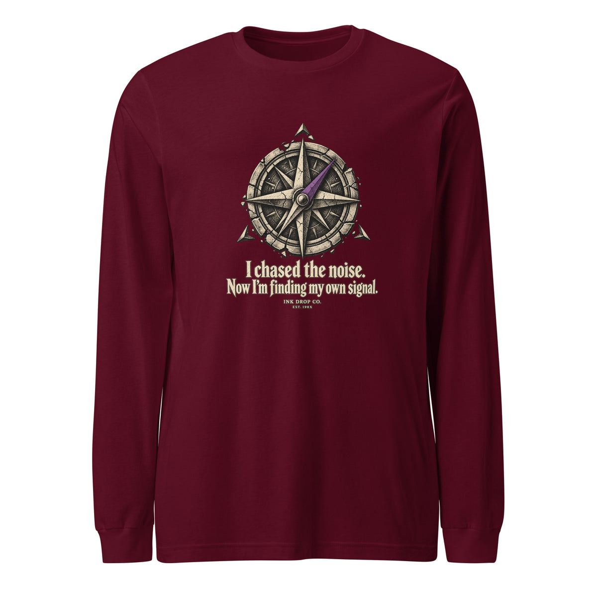 Maroon unisex long sleeve crewneck tee with compass-style graphic and slogan on chest